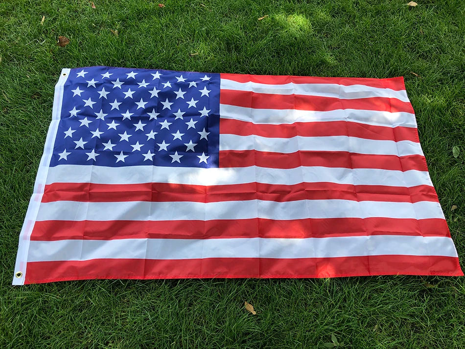 Premium USA Flag displayed on green grass, featuring vibrant red stripes, white stripes, and blue field with 50 stars