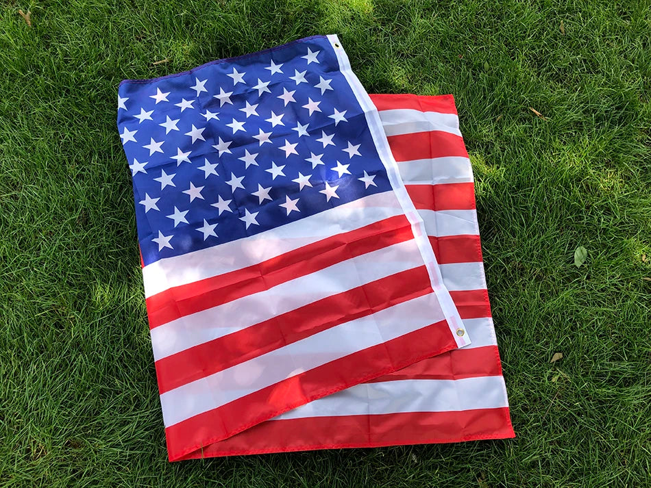 Premium USA Flag displayed on green grass, showing vibrant red stripes, white stripes and blue field with 50 stars - double-sided polyester