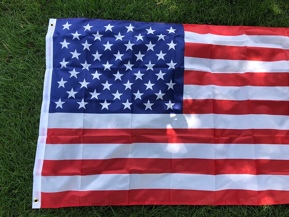 Premium USA Flag with vibrant red, white, and blue stripes and stars displayed on green grass - double-sided polyester outdoor flag