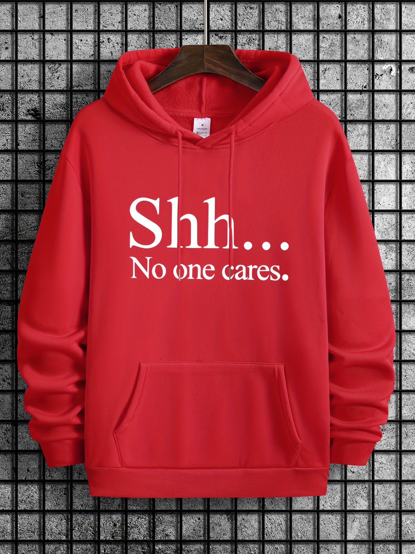 Red pullover hoodie with "Shh... No One Cares" text in white print, featuring kangaroo pocket and classic drawstring design