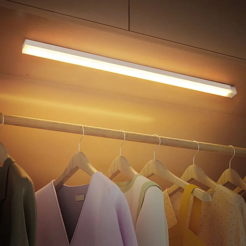HighPeak Motion Sensor Light mounted inside a wooden closet, emitting warm LED light above hanging clothes.