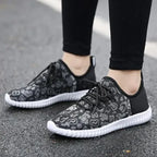 HighPeak Glowstride Sneakers in black and gray leopard print with white sole worn outdoors on asphalt