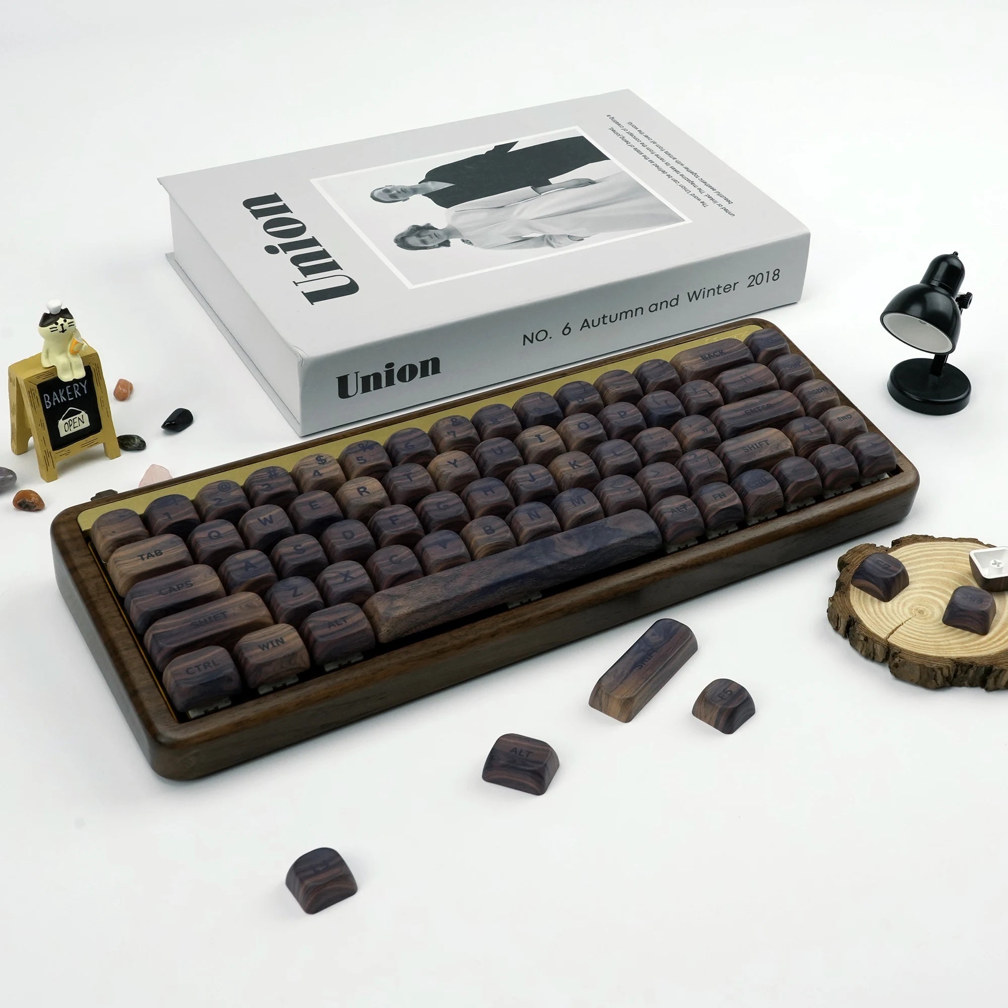 HighPeak Dark Walnut Keycap Set on a wooden keyboard frame with artisan wood texture, surrounded by mini decor on white surface