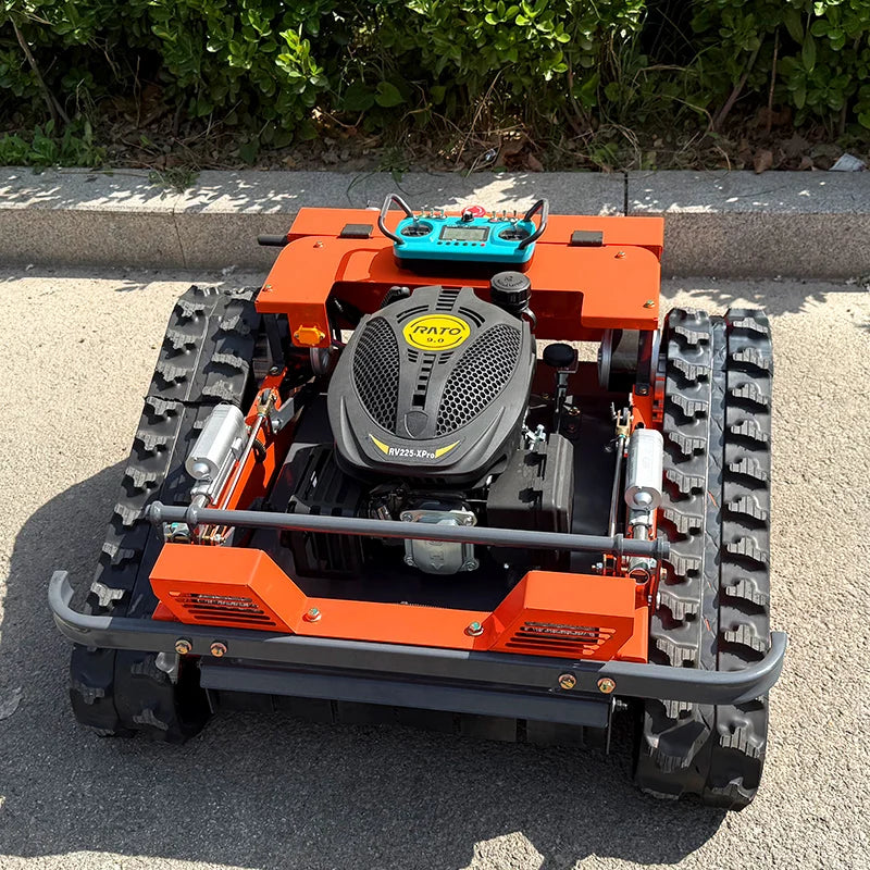 HighPeak Self-Driving Lawn Mower in orange with tracked crawler wheels and remote control on pavement near greenery