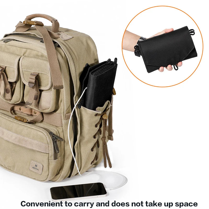 SunVolt Solar Panel in black folded beside tan backpack charging a phone, portable lightweight solar charger by HighPeak