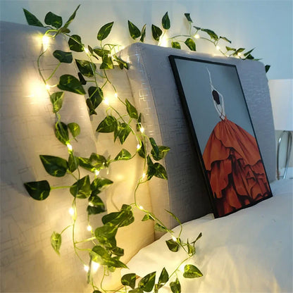 HighPeak GlowVine Lights glowing warm ivy vines draped on beige headboard with framed art in cozy bedroom setup