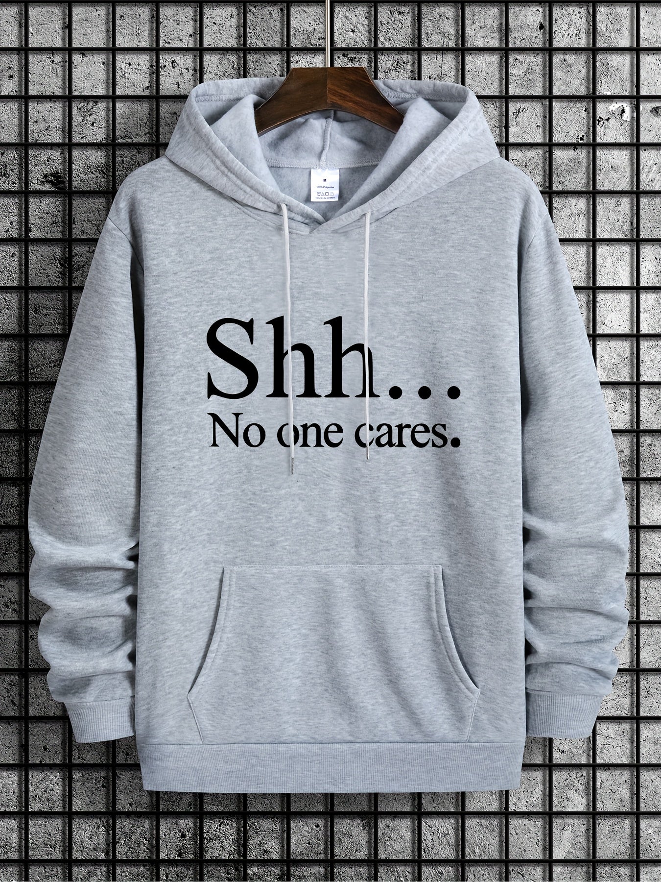 SHH No One Cares hoodie in light gray with black text print, front kangaroo pocket, casual streetwear design