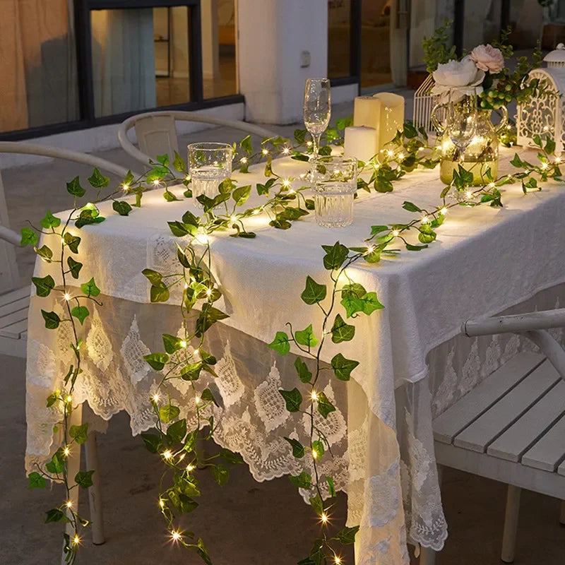 GlowVine Lights by HighPeak draped over outdoor dining table with glowing ivy vines and warm LED lights.