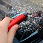 SafeStrike emergency car escape tool in red aluminum breaking car glass with spring-loaded tungsten tip demonstrating instant shatter