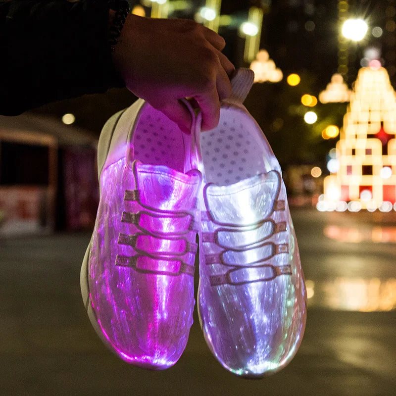 HighPeak Glowstride Sneakers glowing purple and white LED fiber optic lights held in hand against city night background