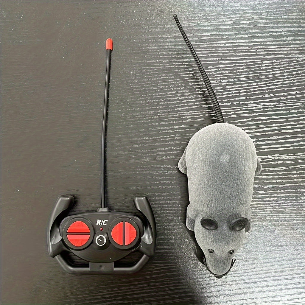 ScamperBot remote-control mouse toy in grey with black wireless controller on dark surface - interactive pet play gadget