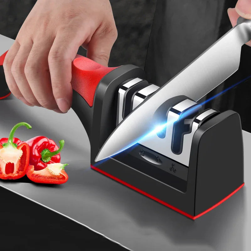 HighPeak Knife Sharpener with red grip sharpening a kitchen knife on a black counter next to sliced red bell peppers