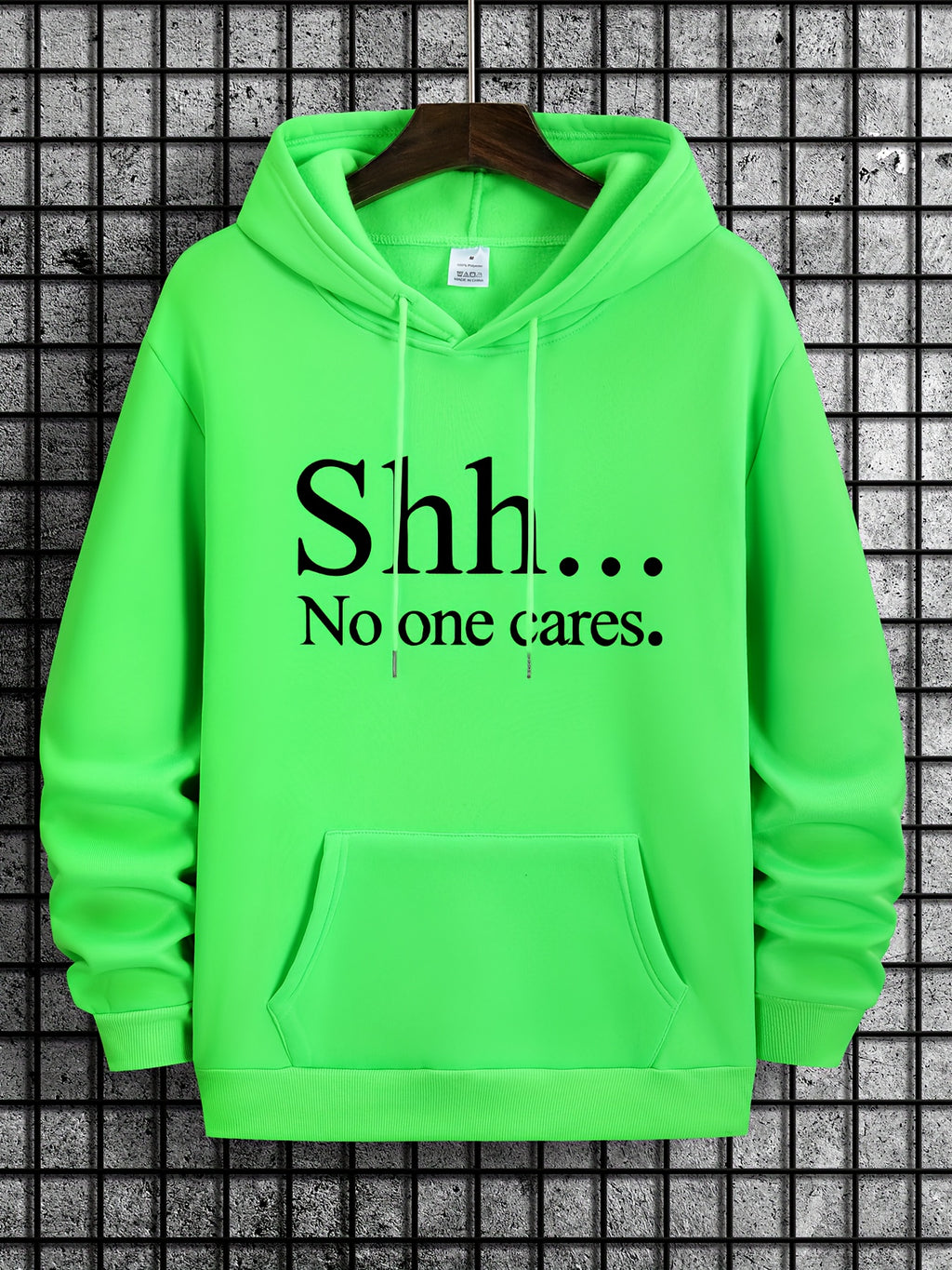 Shh No One Cares Hoodie in neon green with black text print and kangaroo pocket against grid background