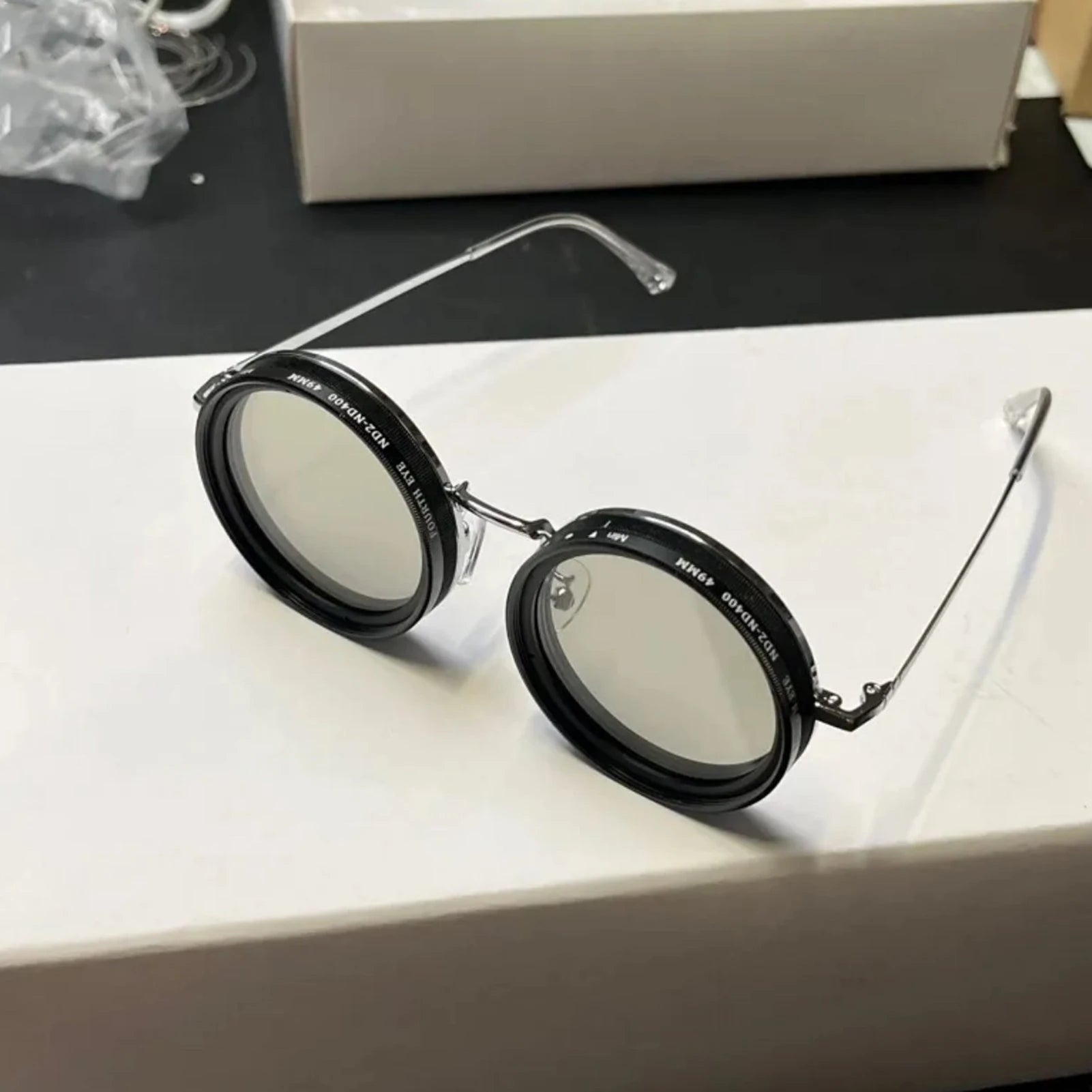 ShiftLens round adaptive sunglasses with silver frames and adjustable lenses on white surface - modern eyewear design