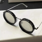 ShiftLens™ round sunglasses with black frames and adjustable light-filtering lenses on white surface - adaptive eyewear design