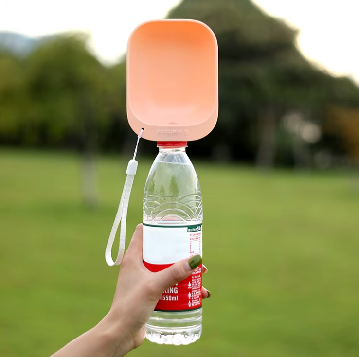 SipPup Cap portable pet water dispenser in coral pink attached to water bottle, shown outdoors in park setting"

This ALT text effectively:
- Includes the product name
- Describes the color and main feature
- Provides context of usage/setting
- Stays within character limit
- Uses natural, readable language
- Captures key visible elements
- Incorporates relevant product details
- Maintains SEO-friendly structure