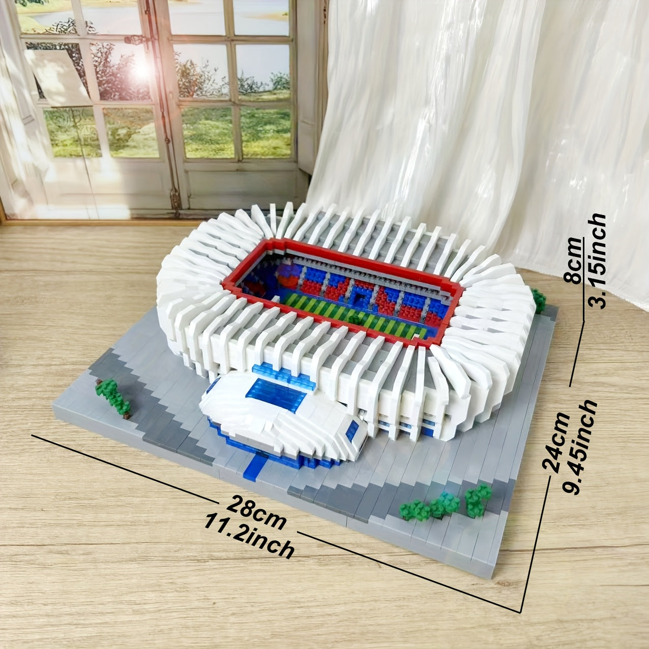 StadiumMaster building set displayed as completed football stadium model with white exterior, red-blue field, and detailed dimensions