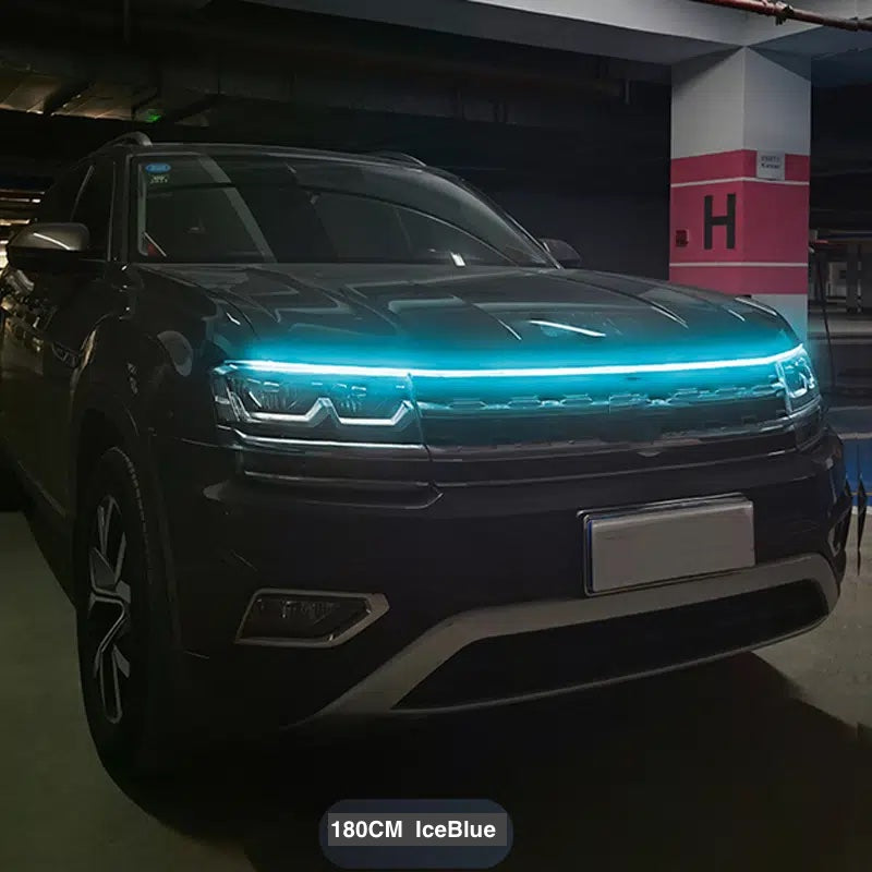 StrikeLine LED hood light strip glowing bright blue on black SUV in dark parking garage, showcasing sleek automotive lighting