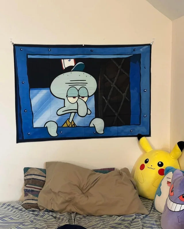 Tentacle Vibes tapestry featuring grumpy Squidward character with blue border, displayed over bed with plush toys