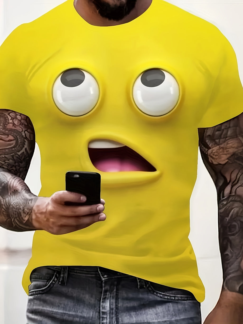 The Bruh Tee in bright yellow featuring 3D emoji face design with rolling eyes and open mouth, person holding smartphone