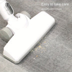 White vacuum cleaner head cleaning carpet with debris - quality cleaning demonstration on gray fabric