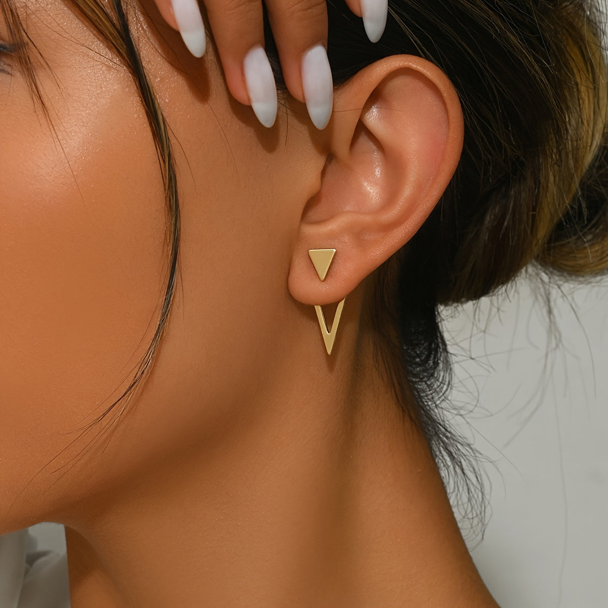 HighPeak Geometric Gold Earrings featuring gold-plated triangle studs and dangling design on a model’s ear in natural light