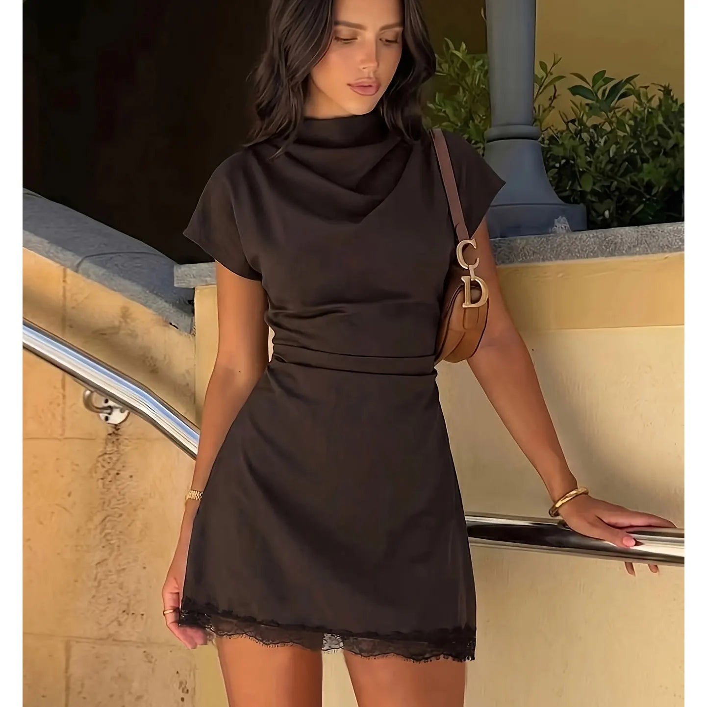 Amorette Lace Mini Dress worn outdoors in golden-hour light with draped neckline and lace hem