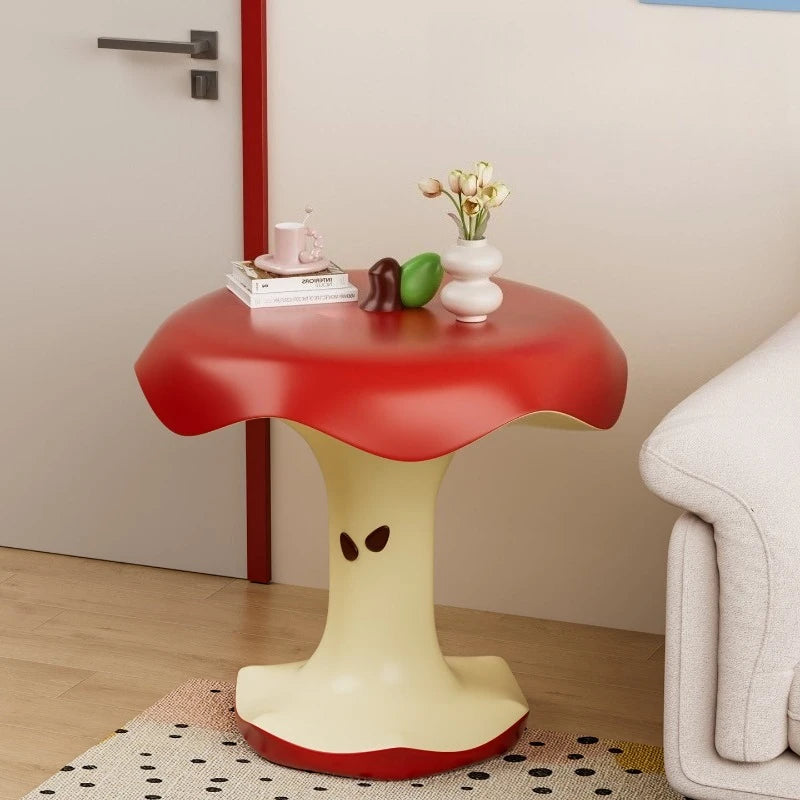 Apple Bite Side Table with books and a flower vase beside an entryway door