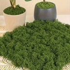 Artificial Decorative Moss spread across a patterned tabletop in front of white and gray moss-topped planters.