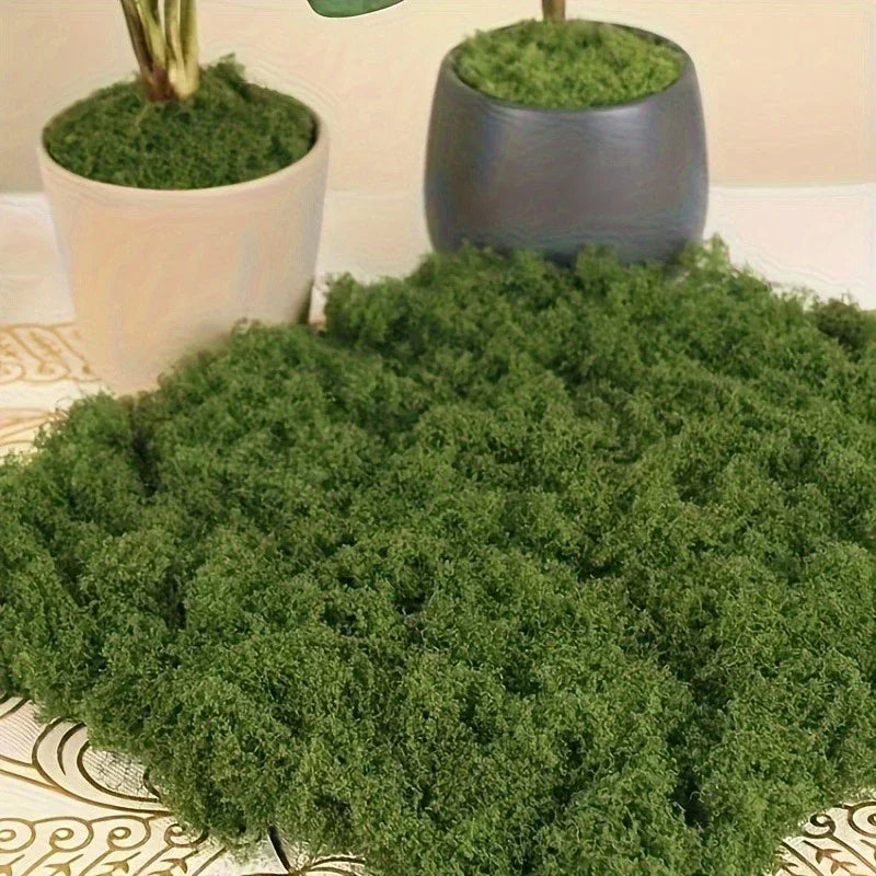 Artificial Decorative Moss spread across a patterned tabletop in front of white and gray moss-topped planters.