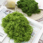Artificial Decorative Moss loose green portions displayed over an open magazine and a woven placemat.