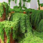 Artificial Decorative Moss draped over wooden display stands with cascading strands and dense green texture.