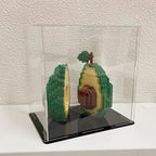Avocado Building Block Set with both completed halves shown inside a clear display case on a white shelf