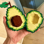 Avocado Building Block Set held open in one hand, showing the brown pit and hollow matching half