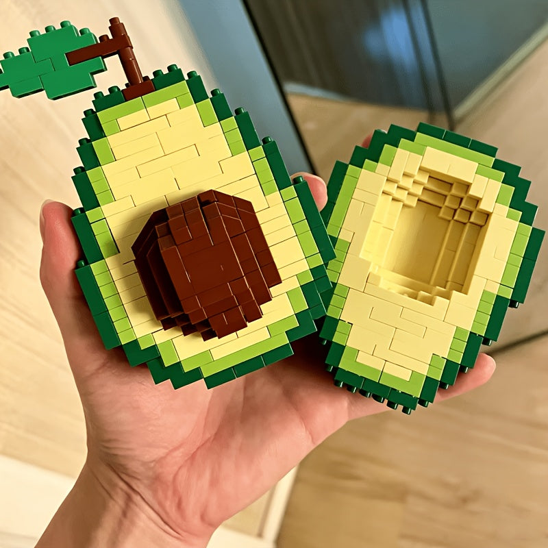 Avocado Building Block Set held open in one hand, showing the brown pit and hollow matching half