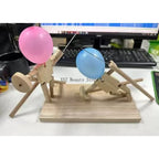 Balloon Fencing Battle Game with pink and blue balloon fighters posed in front of a computer keyboard.