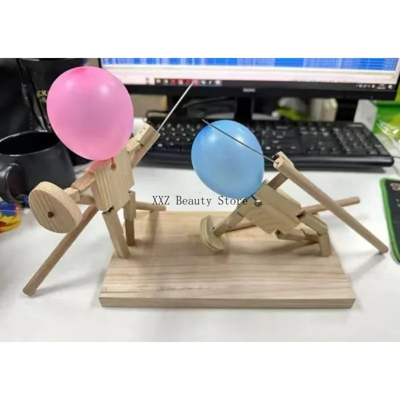 Balloon Fencing Battle Game with pink and blue balloon fighters posed in front of a computer keyboard.