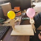 Balloon Fencing Battle Game with yellow and pink balloons on a desk beside a keyboard.