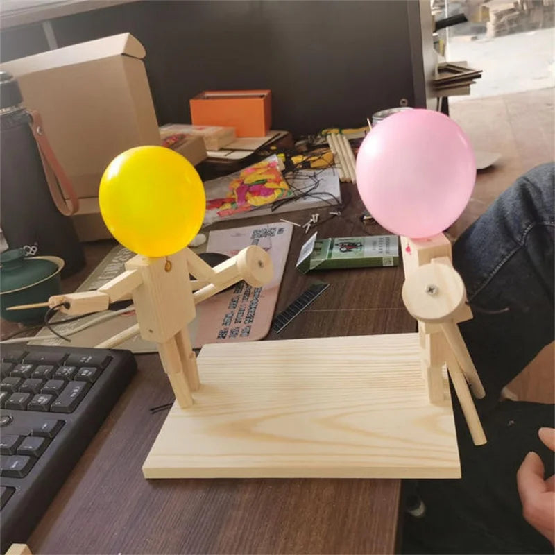 Balloon Fencing Battle Game with yellow and pink balloons on a desk beside a keyboard.