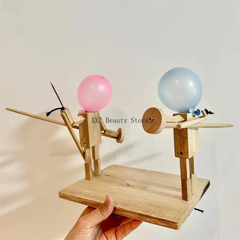 Balloon Fencing Battle Game assembled base held in one hand, showing both wooden fighters and their controls.