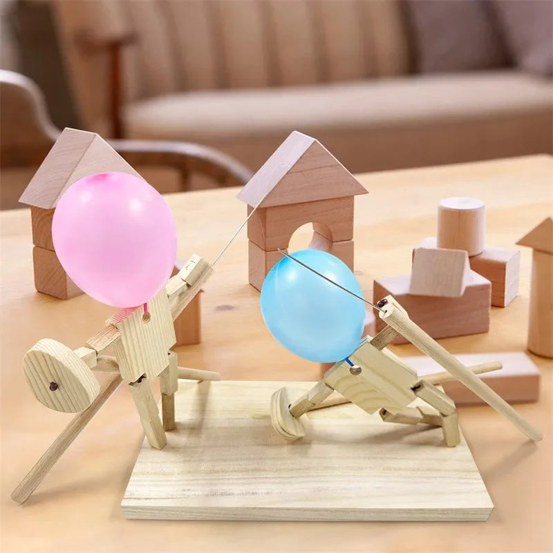 Balloon Fencing Battle Game with pink and blue balloons posed beside wooden building blocks.