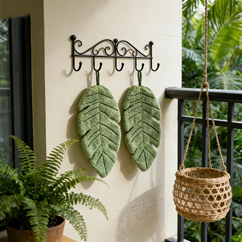 Banana Leaf Hand Towels hanging beside tropical plants in a bright room