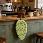 Banana Leaf Hand Towel hanging from a rustic cafe counter