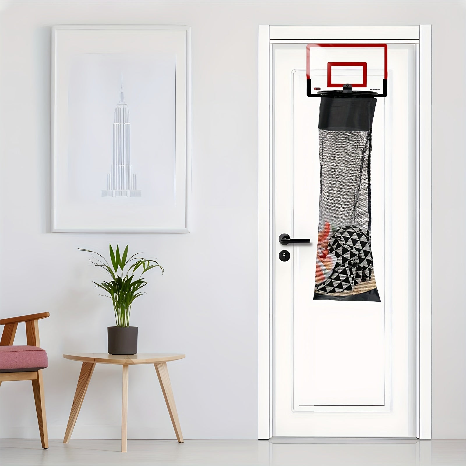 HighPeak SwishBin Laundry Hoop in red and black hanging over a white door with laundry inside in a modern room setting