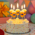 Beer Birthday Candles arranged at staggered heights on a white birthday cake, with all five candles lit.