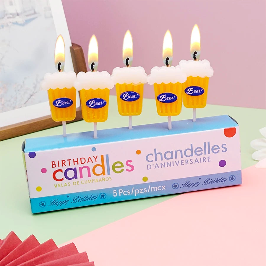 Beer Birthday Candles lit above a five-piece birthday candle box, showing yellow glasses and white foam tops.