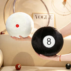 Billiard Ball Plush Set white cue ball and black 8 ball held on open palms to show their scale.