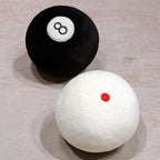 Billiard Ball Plush Set black 8 ball and white cue ball with a red dot on a pale surface.