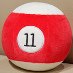 Billiard Ball Plush Set red striped number 11 ball resting on a beige seat.