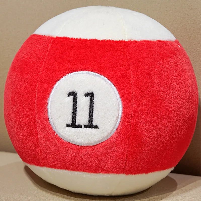 Billiard Ball Plush Set red striped number 11 ball resting on a beige seat.